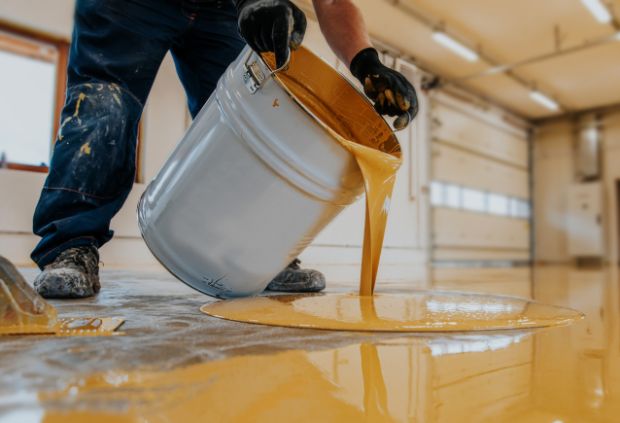Epoxy garage flooring installation in Sydney by Epoxy Flooring Guys, pouring high-quality epoxy coating for a durable, stain-resistant, easy-clean garage floor finish.