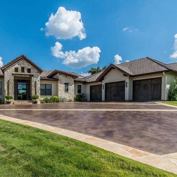 Modern home with dark epoxy driveway coating, installed by Epoxy Flooring Guys Sydney. Clean finish with contrasting border detail.