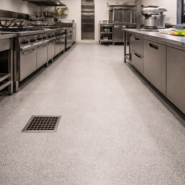 Close-up of commercial kitchen epoxy floor by Epoxy Flooring Guys Sydney, with durable, easy-clean finish and drainage.