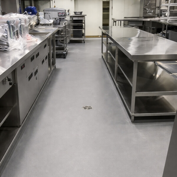 Commercial kitchen epoxy flooring in Sydney with smooth, seamless epoxy floor and central floor drain by Epoxy Flooring Guys Sydney.